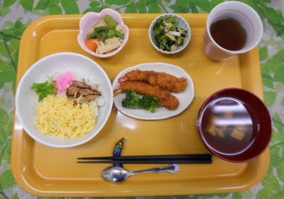 介護施設の食事風景。黄色いトレーに配置された栄養バランスの良い食事セット